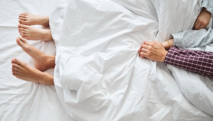 Couple in bed holding hands Couple in bed holding hands